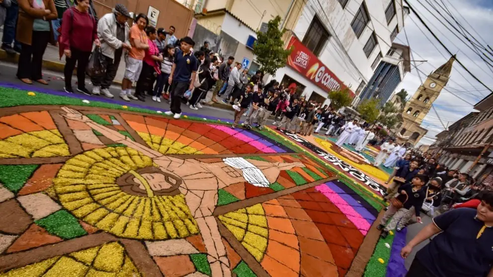 Alfombras florales elaboradas con pétalos y aserrín teñido durante la celebración de Corpus Christi.webp